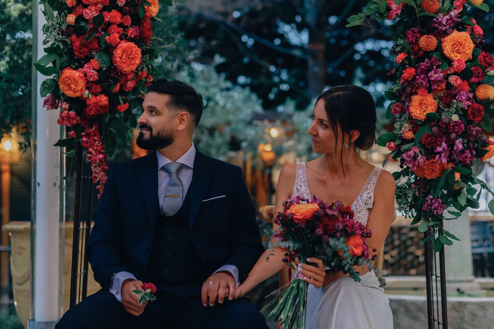 Couple under a colourful floral arch