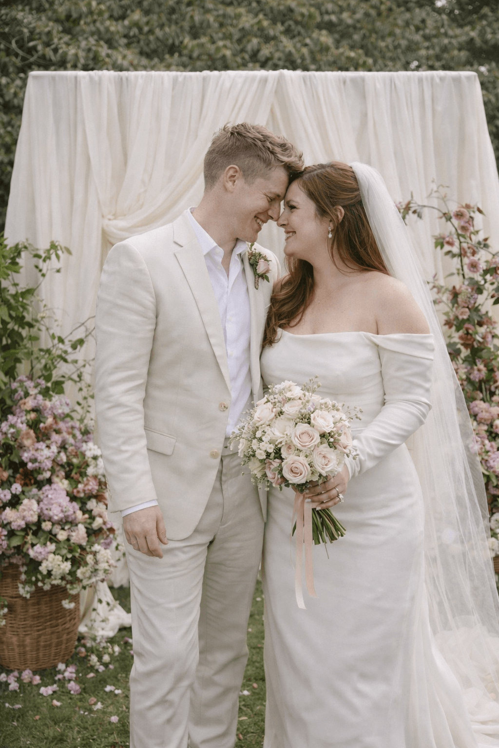 Couple sous une arche florale aux tons pastels