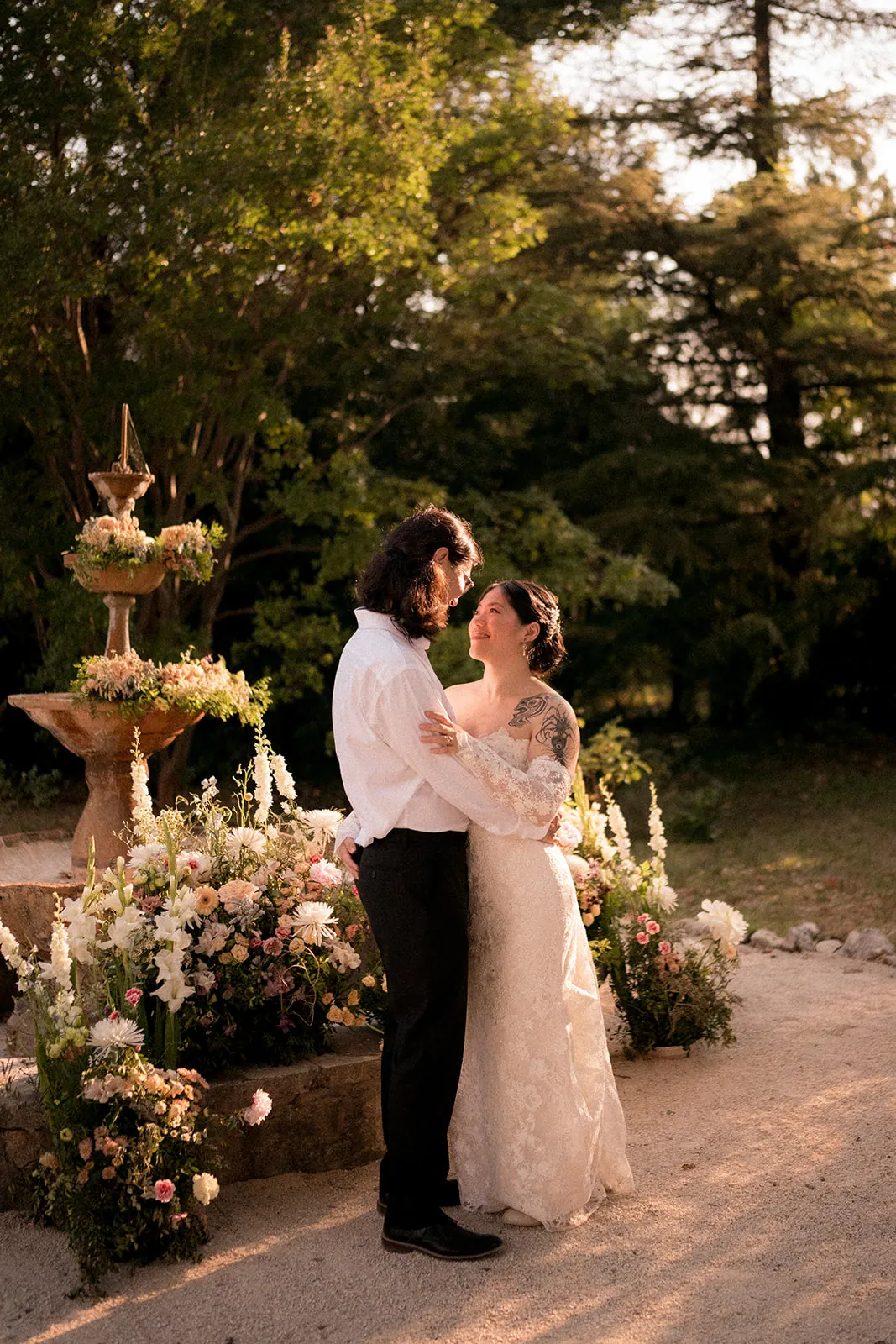 Couple by a fountain at sunset with floral installation