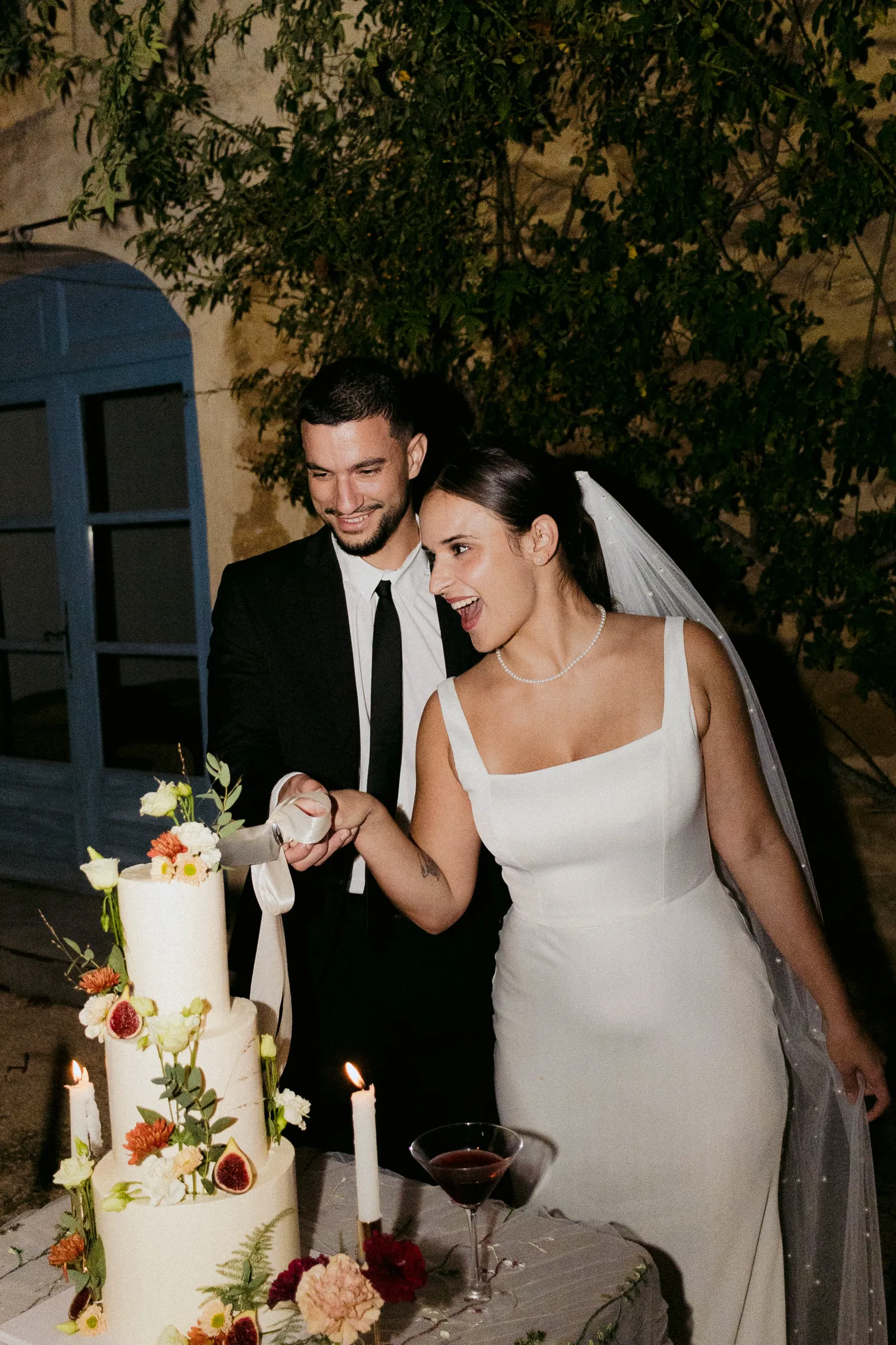Couple cutting a flower-decorated wedding cake