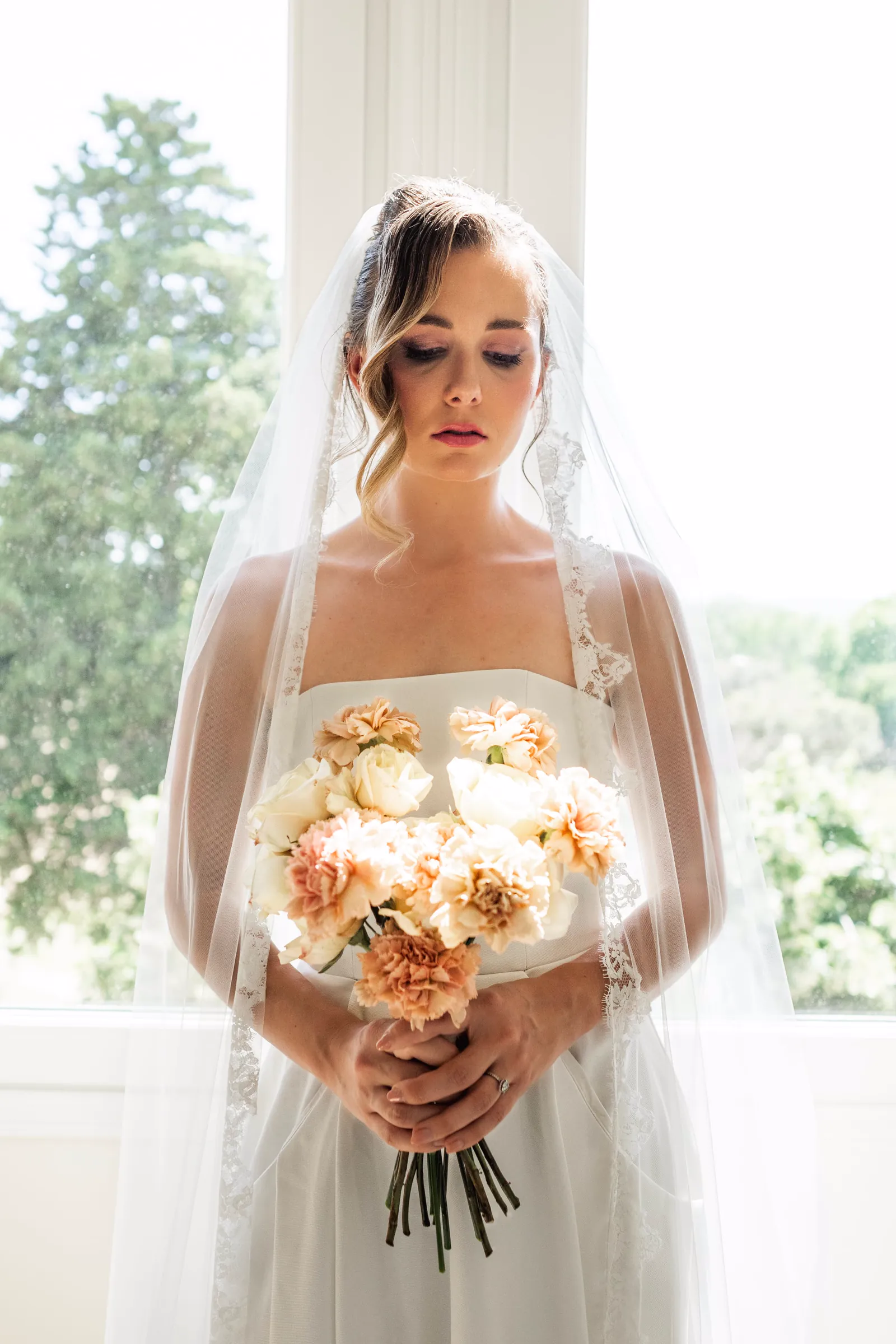 Bride with her veil and a peach bouquet